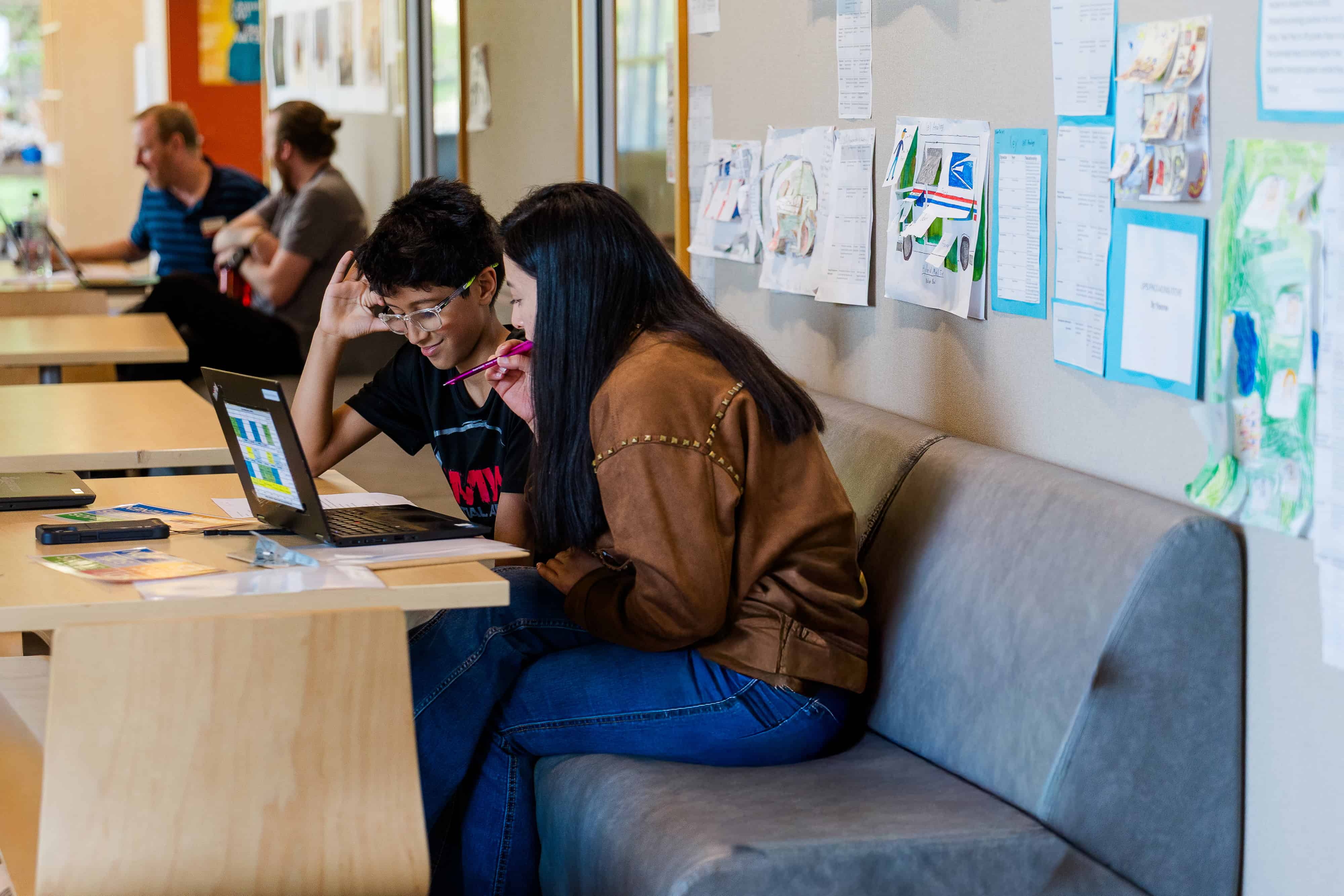 Teacher helping student on laptop