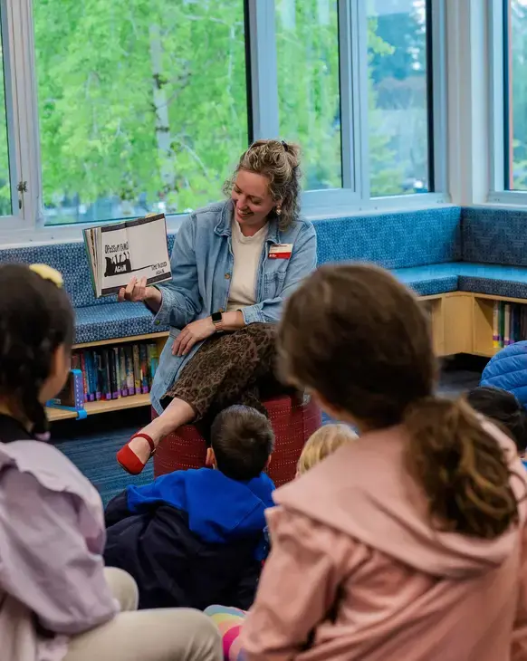 Teacher reading to students in library