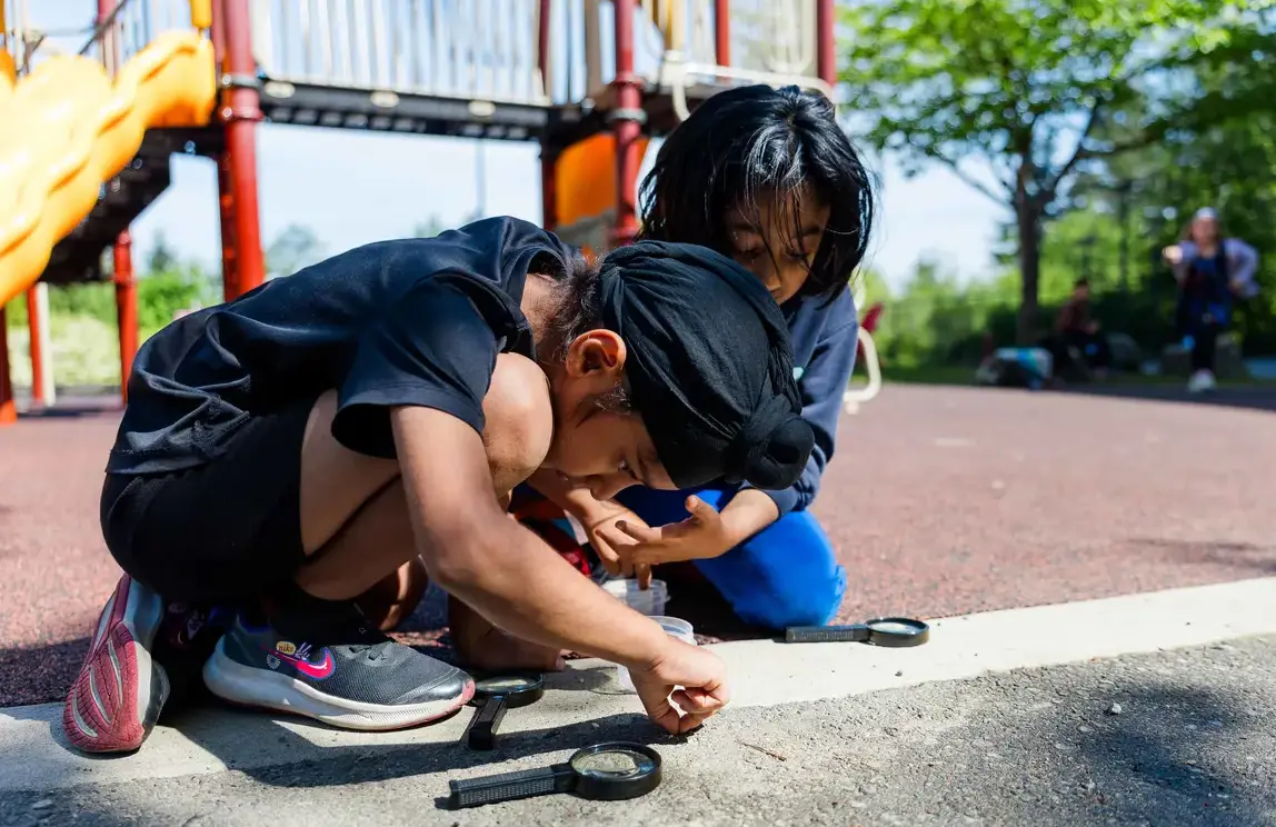 students outside with magnifying glass