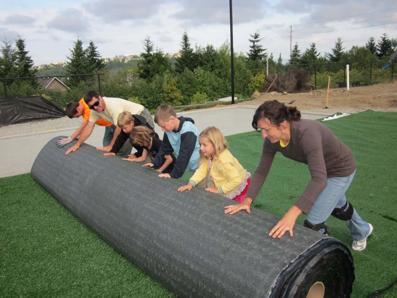 Students and teachers laying astro turf