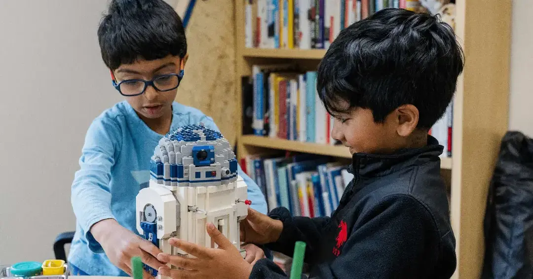 Students building plastic figure together