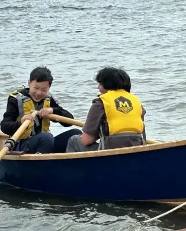 Two students on a boat rowing