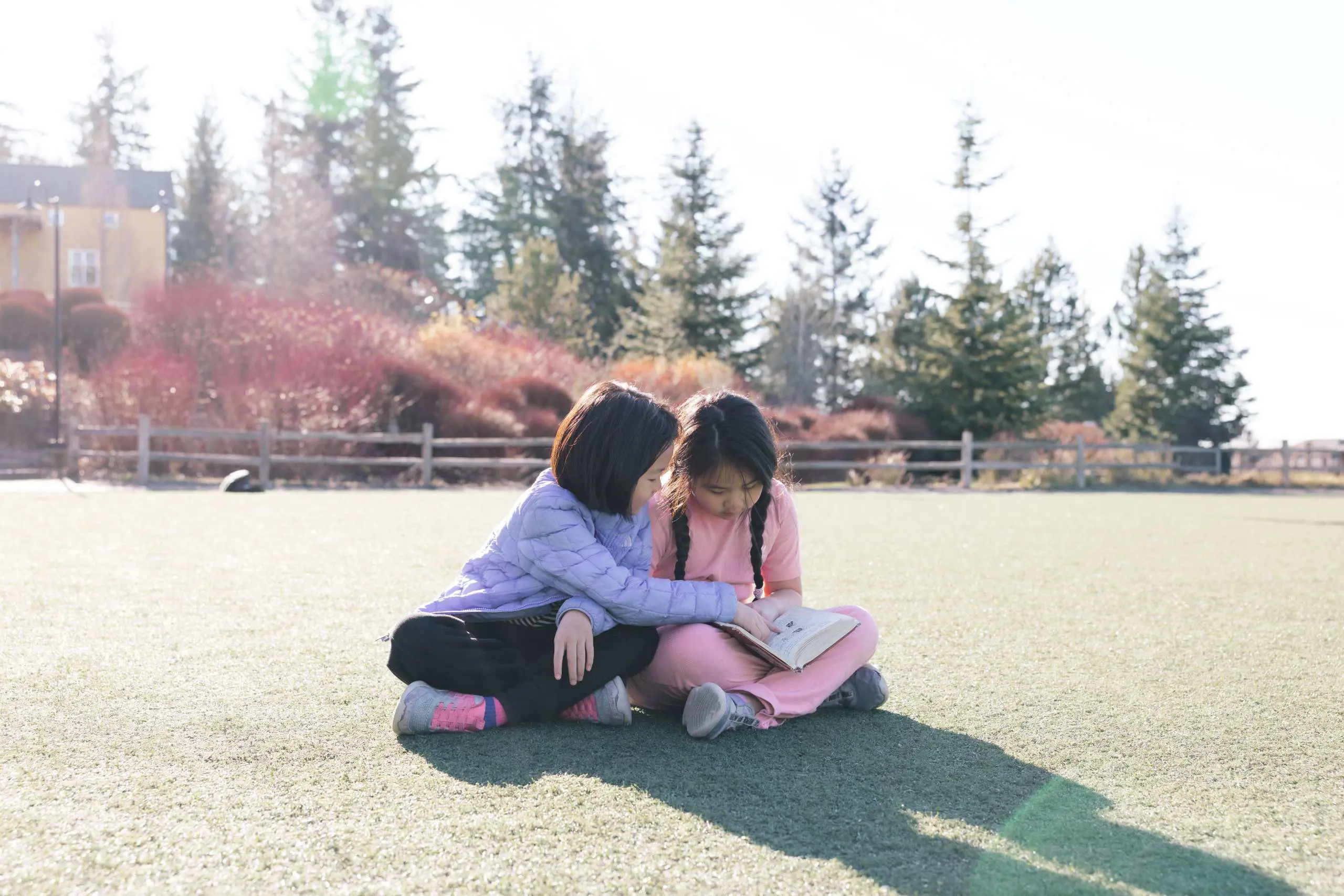 Students reading book together on playground