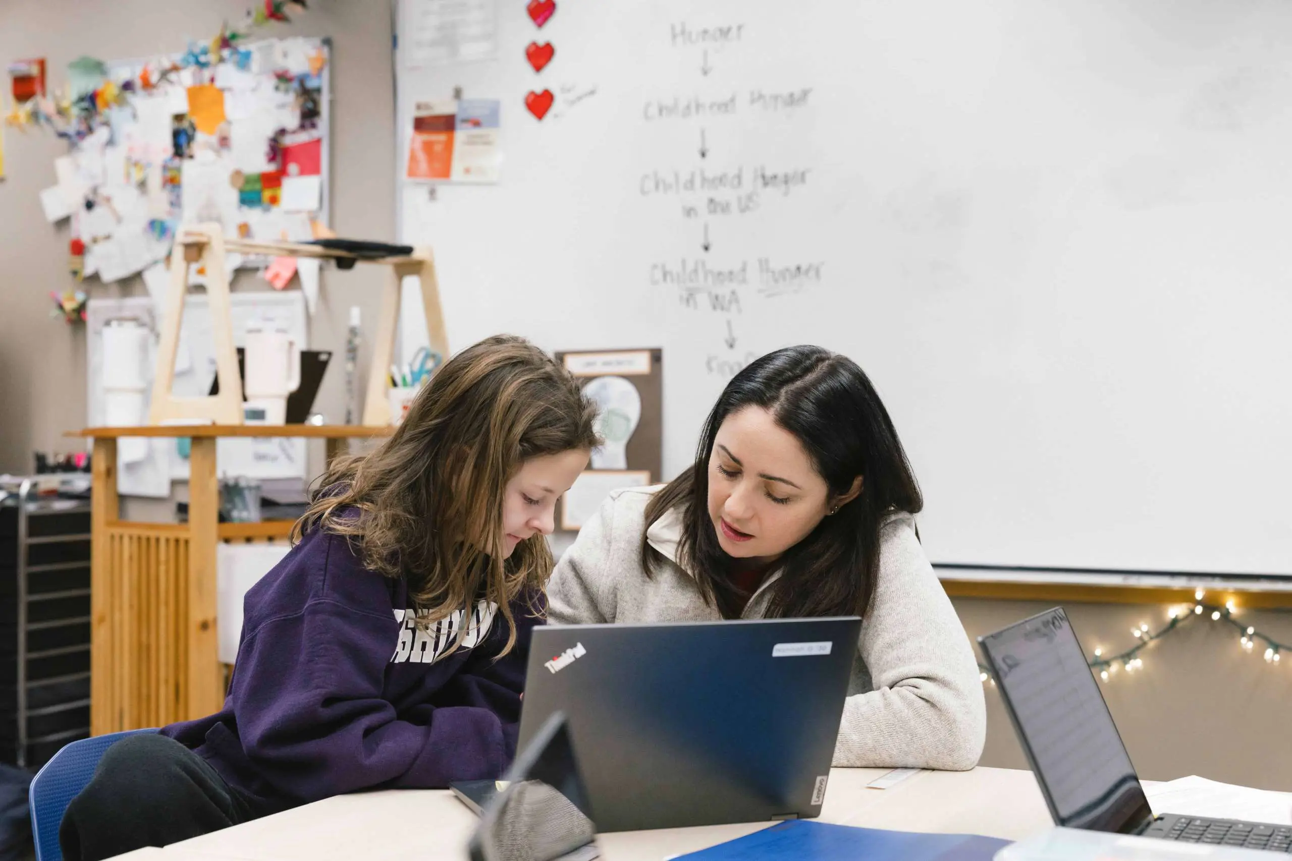 Teacher working with student on laptop