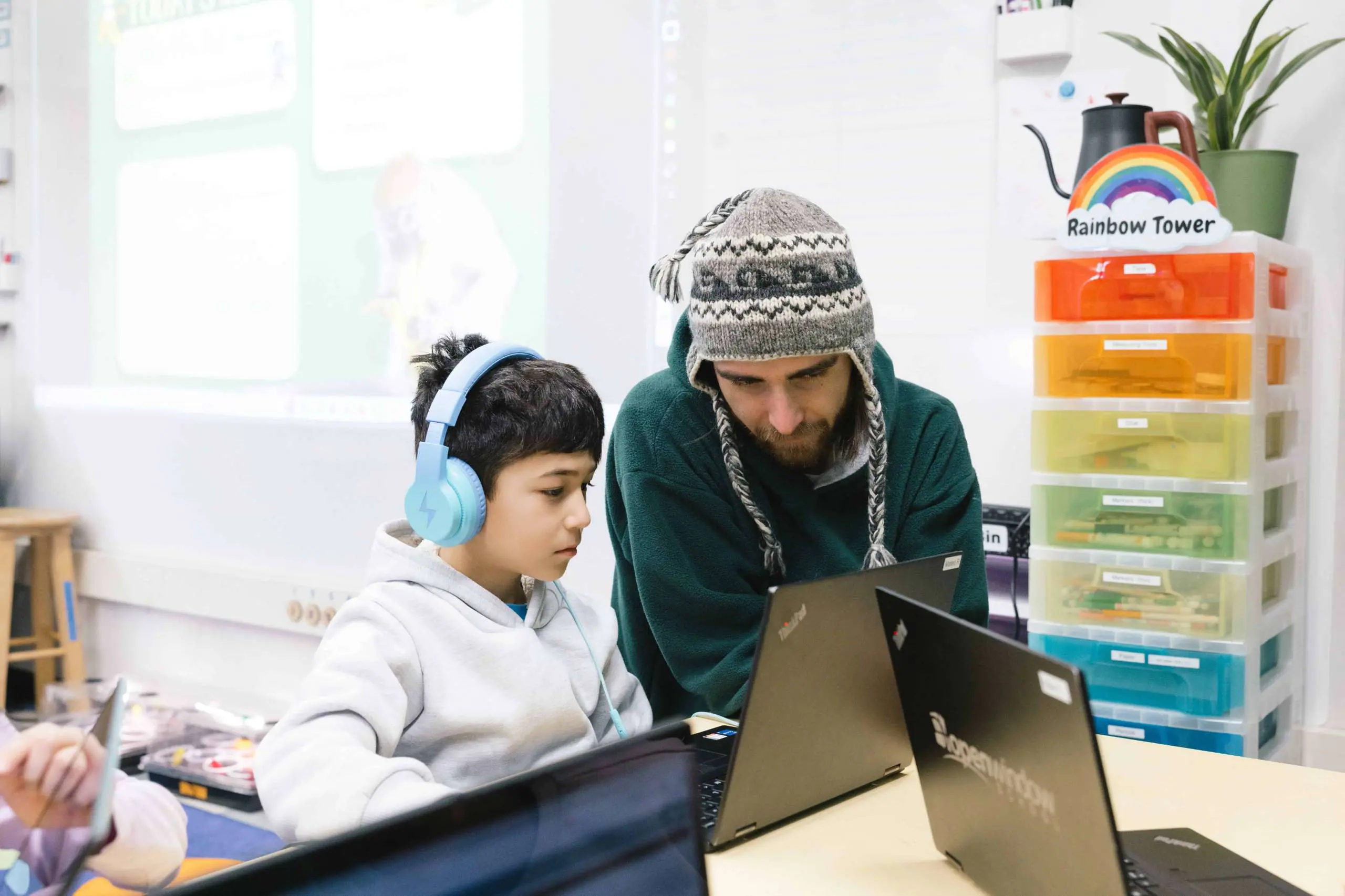 Teacher working with student on laptop
