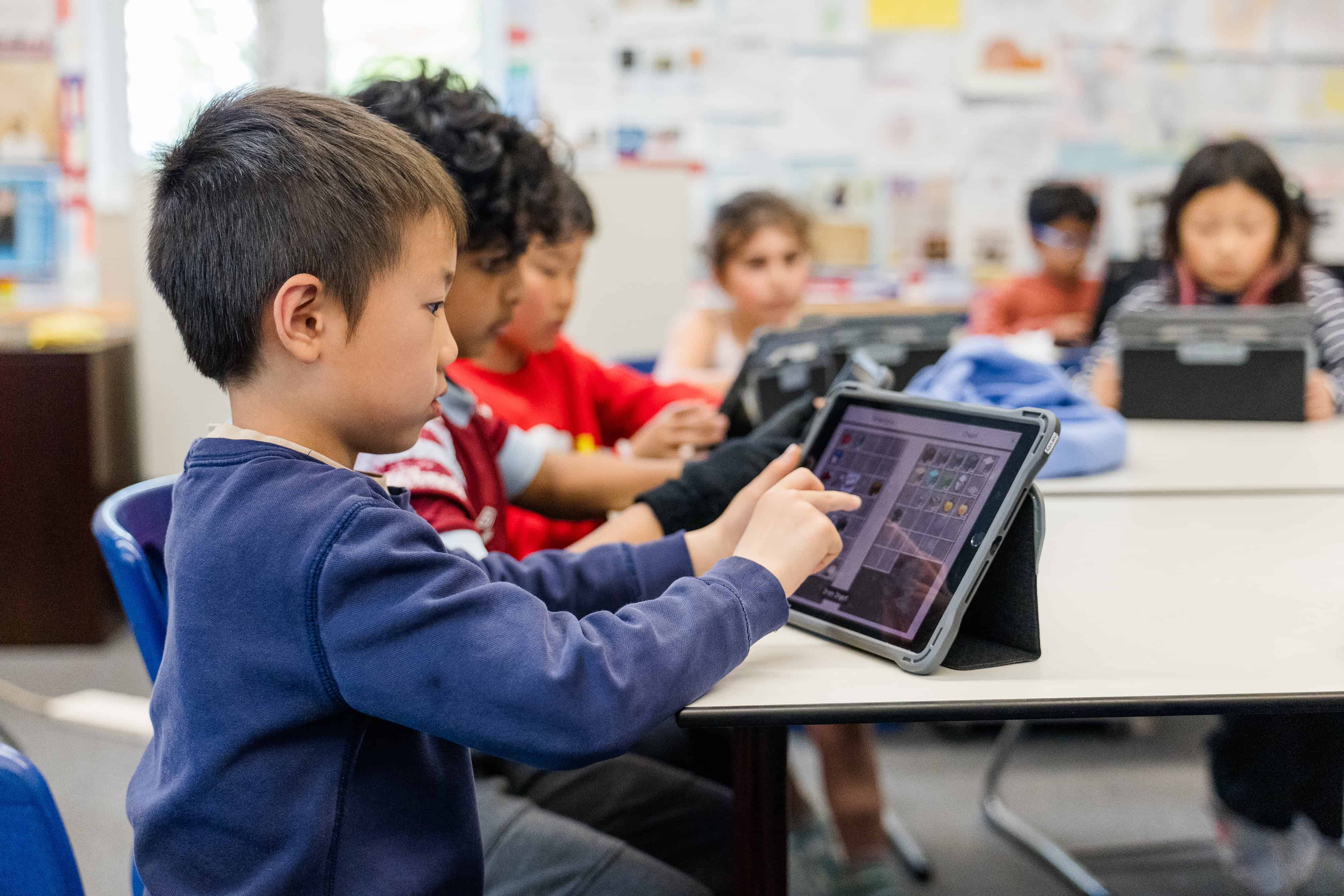 Student playing minecraft on tablet